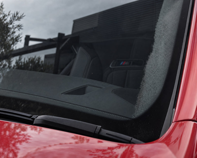 Klare Innenscheibe eines roten BMW M5 nach der Reinigung, an der A-Säule letzter Beschlag — gezeigt im Artikel „Auto beschläg