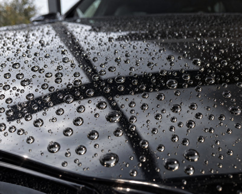 Detailing1 Ergebnis am schwarzen BMW M5 — runde Wasserperlen auf der frisch geschützten Motorhaube